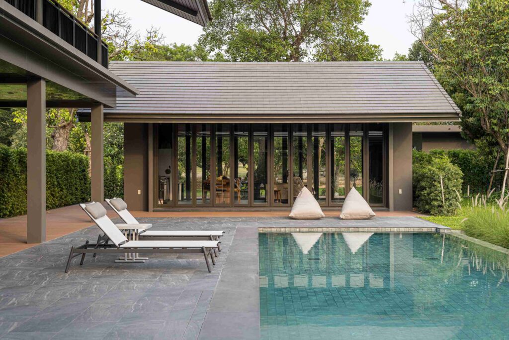 บ้านโมเดิร์นติดตั้งประตูบานเฟี้ยมกระจกเชื่อมพื้นที่ห้องนั่งเล่นและสวนภายนอก